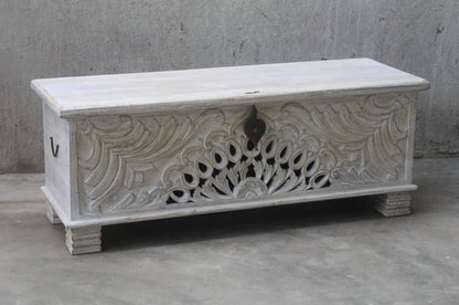 Hand-carved wood storage chest with a rustic finish, front view showing peacock cutouts, dark latch and block feet.