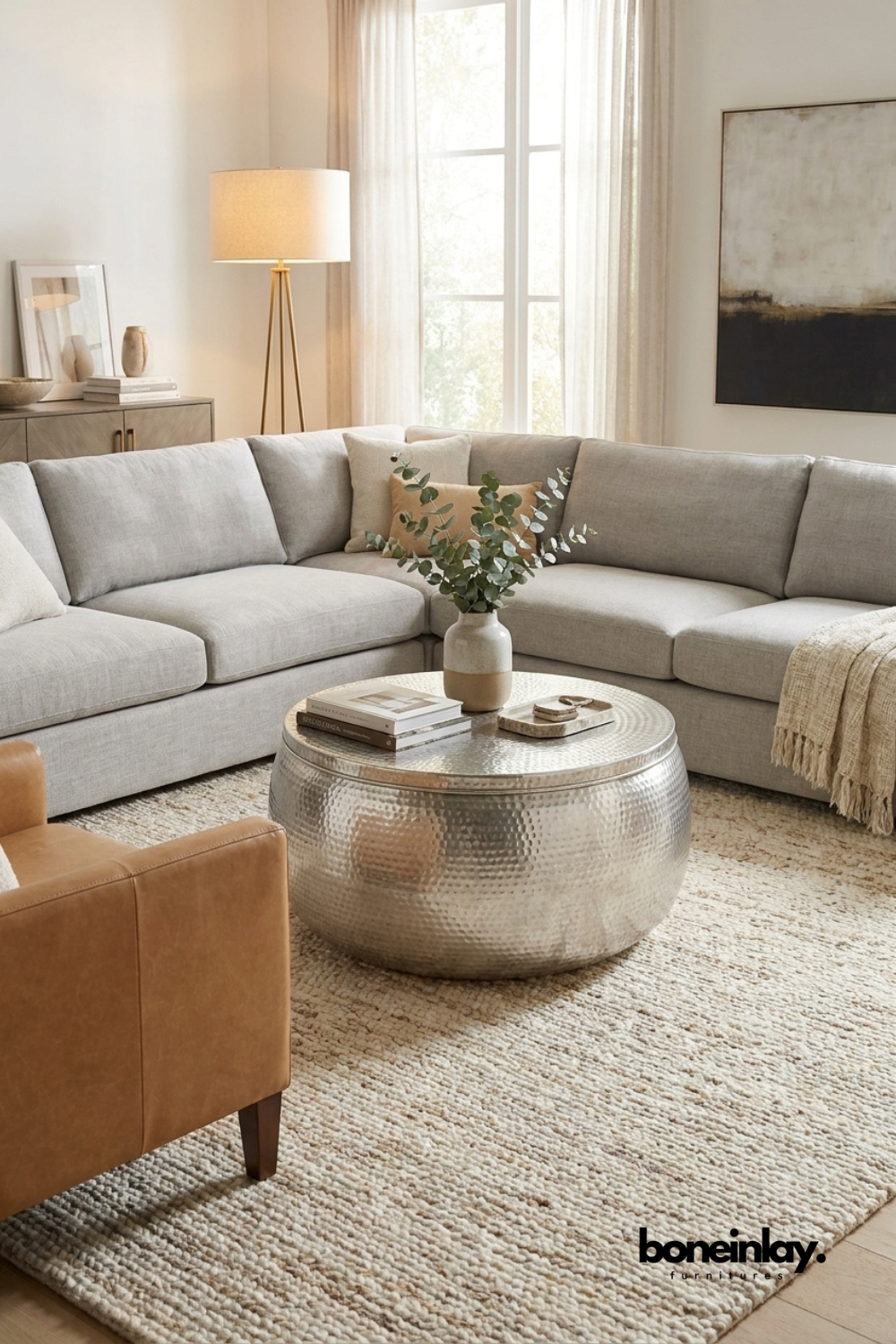 Round hammered silver metal drum coffee table in a modern grey sectional sofa living room setting by Boneinlay Furnitures