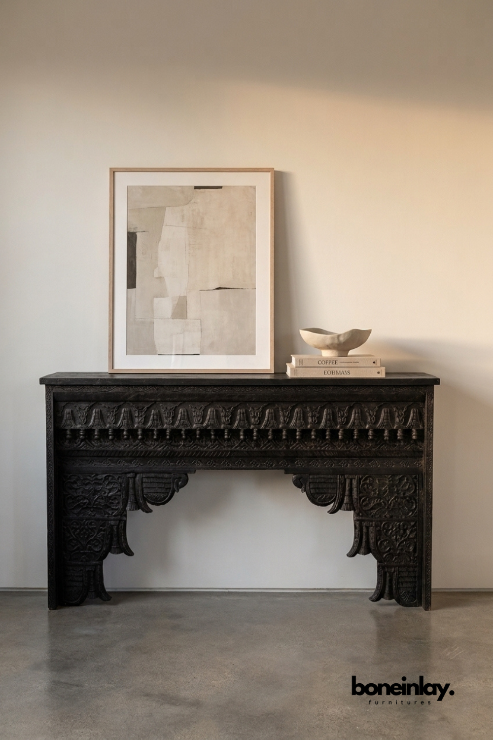 Black hand-carved console table with an ornate carved apron.
Bold scalloped corbel legs feature detailed floral relief carving.
Ebonized wood finish gives it a dramatic, statement-making look.
Styled with a framed art print and ceramic bowl on top.