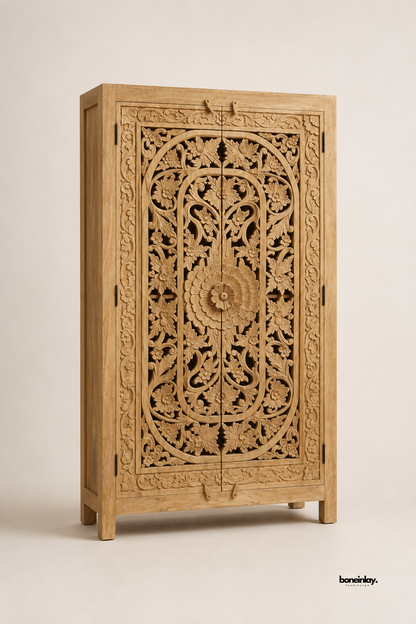 Natural mango wood wardrobe featuring a bold central floral rosette surrounded by dense scrollwork and vine carvings. Tapered wood legs and clean lines add a refined silhouette to the ornate double-door design. Photographed at an angle on a plain studio background to highlight the sculptural carved detail. A striking statement wardrobe for bedrooms and dressing rooms.