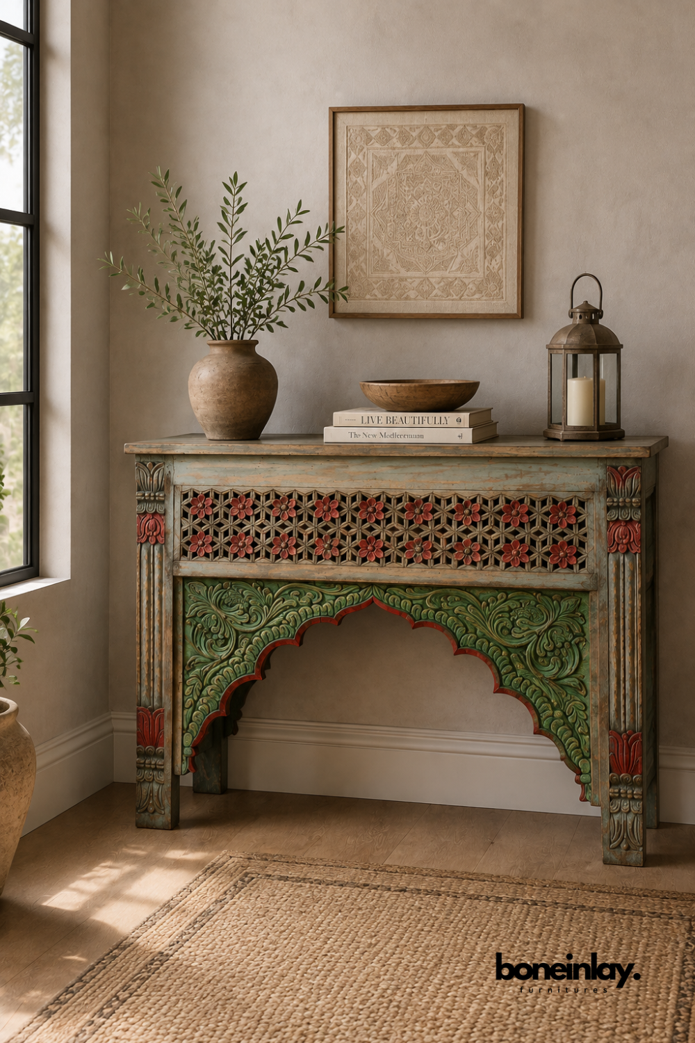 Hand-painted console table with a red, green, and blue Moorish arch design.
Carved star lattice panel and floral motifs decorate the front apron.
Fluted corner legs feature detailed red and green painted accents.
Styled with a rustic vase and lantern in a warm, bohemian entryway.