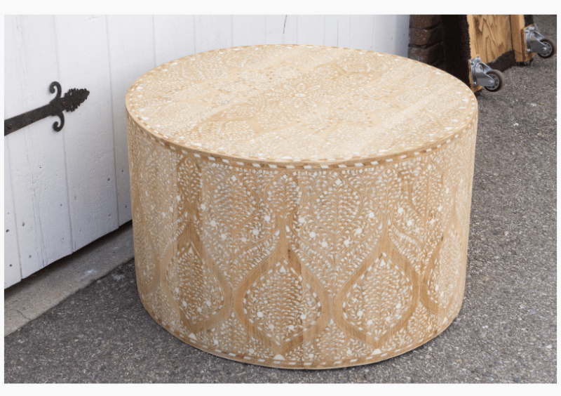 Bone inlay drum coffee table photographed outdoors in natural light, full body view showing intricate floral inlay on natural bleached wood