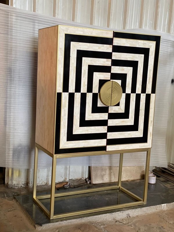 Handcrafted bone inlay bar cabinet featuring bold black and white concentric square optical illusion design with round brass knob and rectangular gold metal base