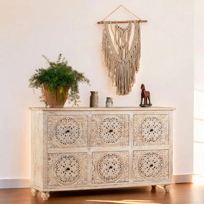 Handcrafted carved wood highboy in cream tone, front view styled with mirror and greenery.