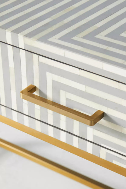 Close detail of handcrafted grey bone inlay console table drawer with brass bar handle and geometric striped pattern
