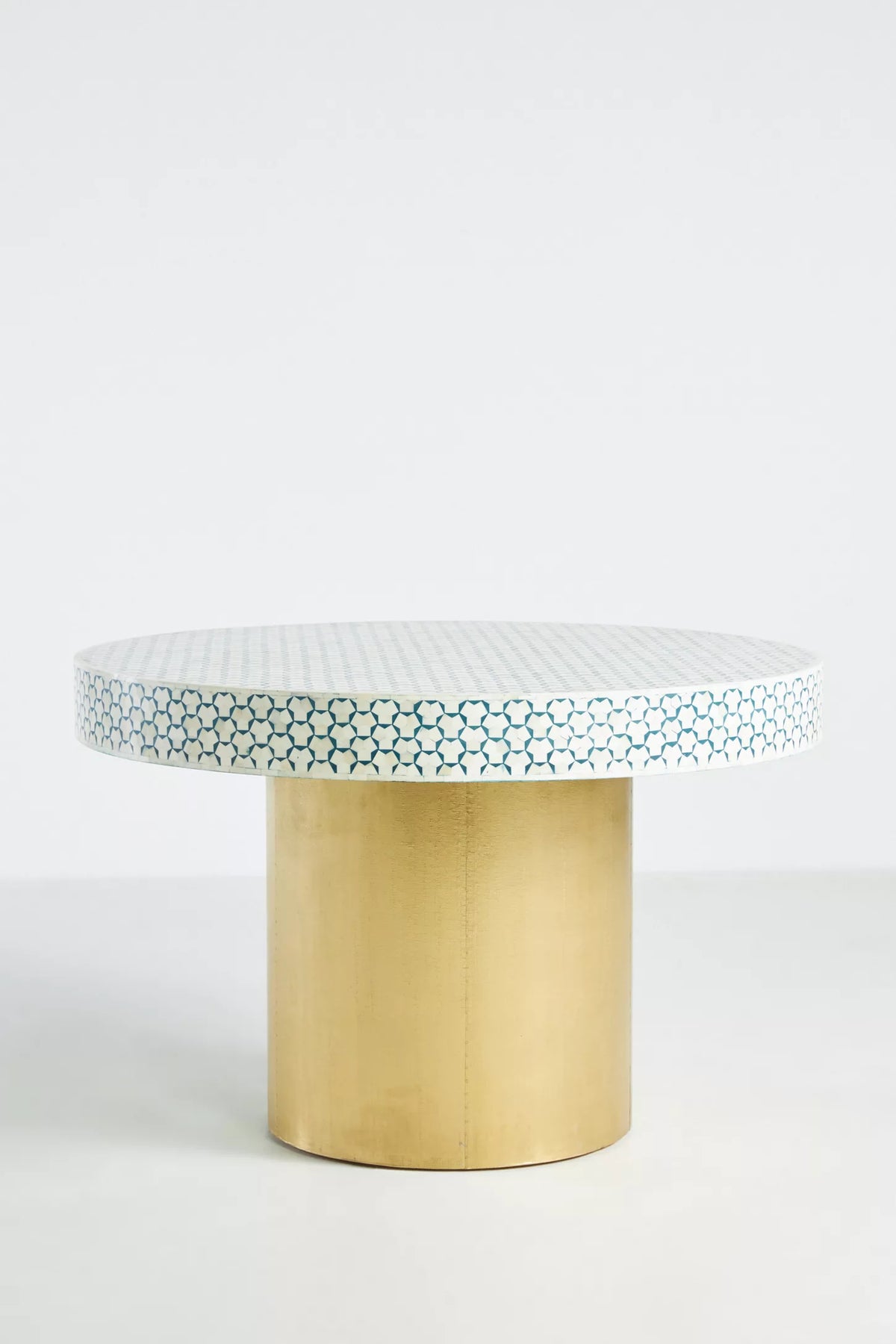 Handcrafted teal and white geometric bone inlay round dining table with gold metal pedestal base on white background