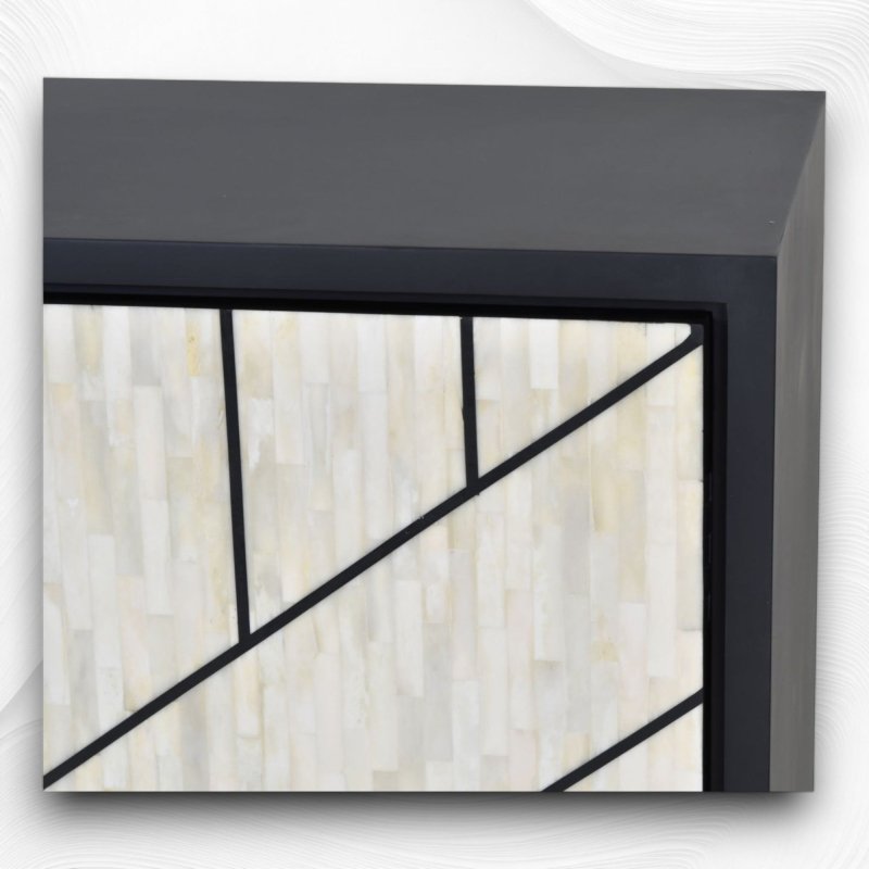 Detailed view of hand-laid ivory bone tile inlay on a black mango wood credenza frame, revealing precise geometric line work and fine artisan craftsmanship quality.