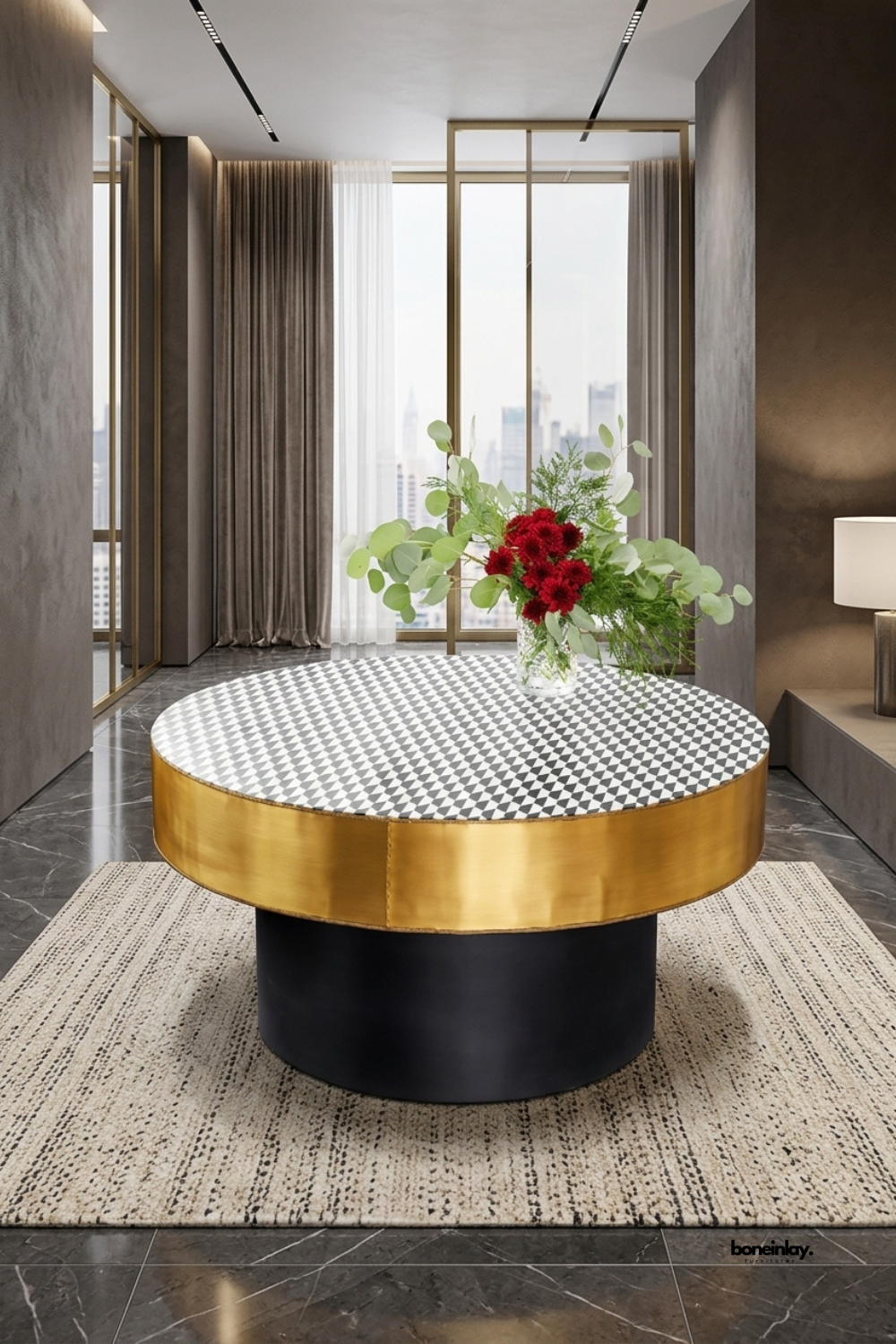 Modern round bone inlay coffee table showcasing a black and white harlequin diamond pattern top, a lustrous brushed gold metal border, and a bold black drum pedestal base. Styled in a luxury penthouse lounge on a neutral patterned rug with fresh floral decor, this statement center table elevates modern living rooms.