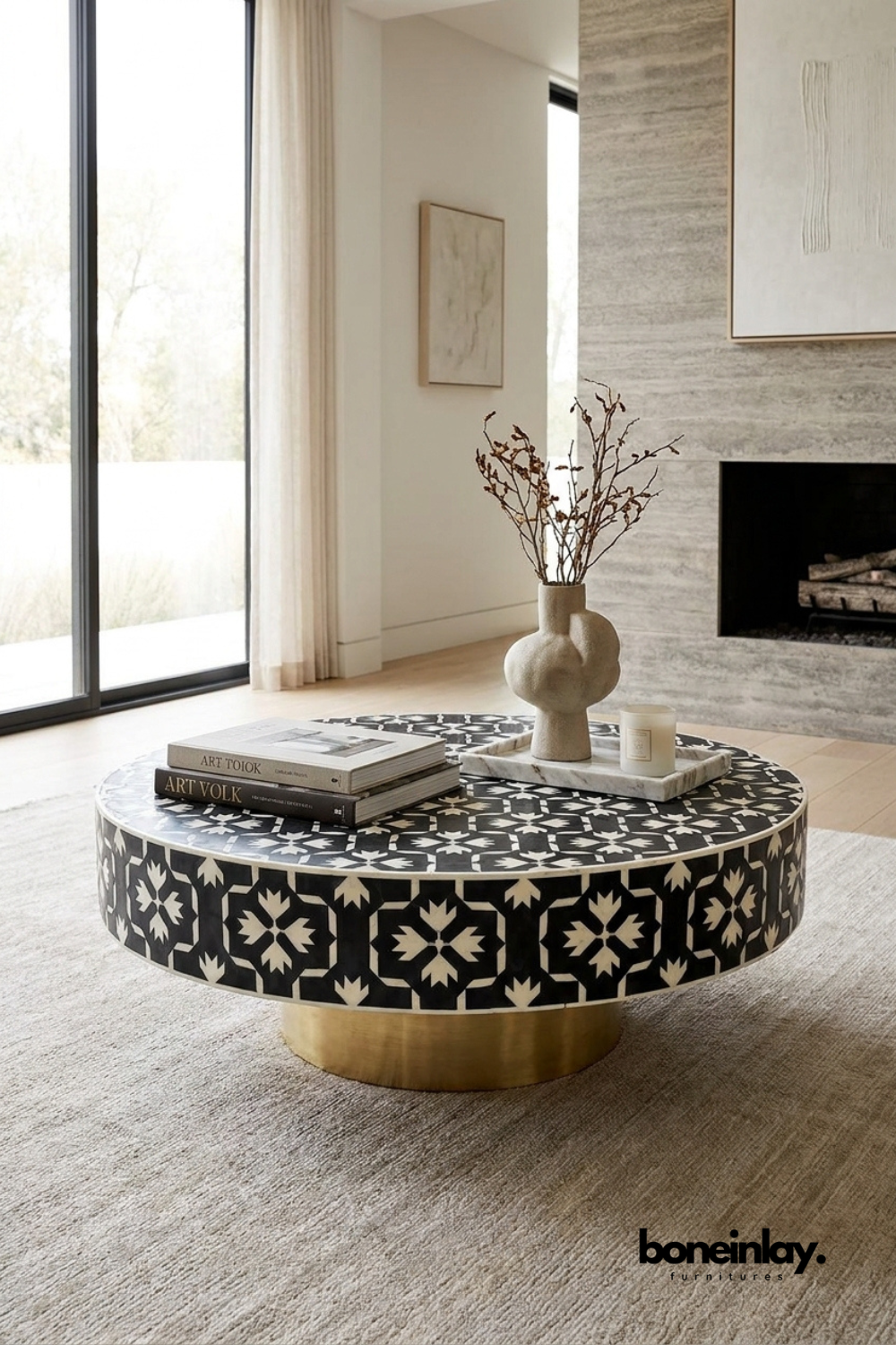 Round black and white bone inlay coffee table with bold geometric pattern and brushed brass pedestal base