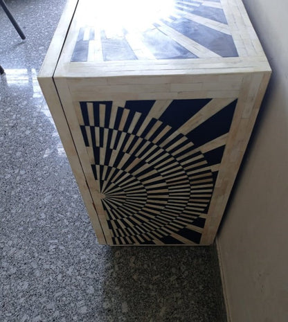 Handmade black and white bone inlay bar cabinet with two doors, a repeating optical pattern, and large circular gold-finished handles.