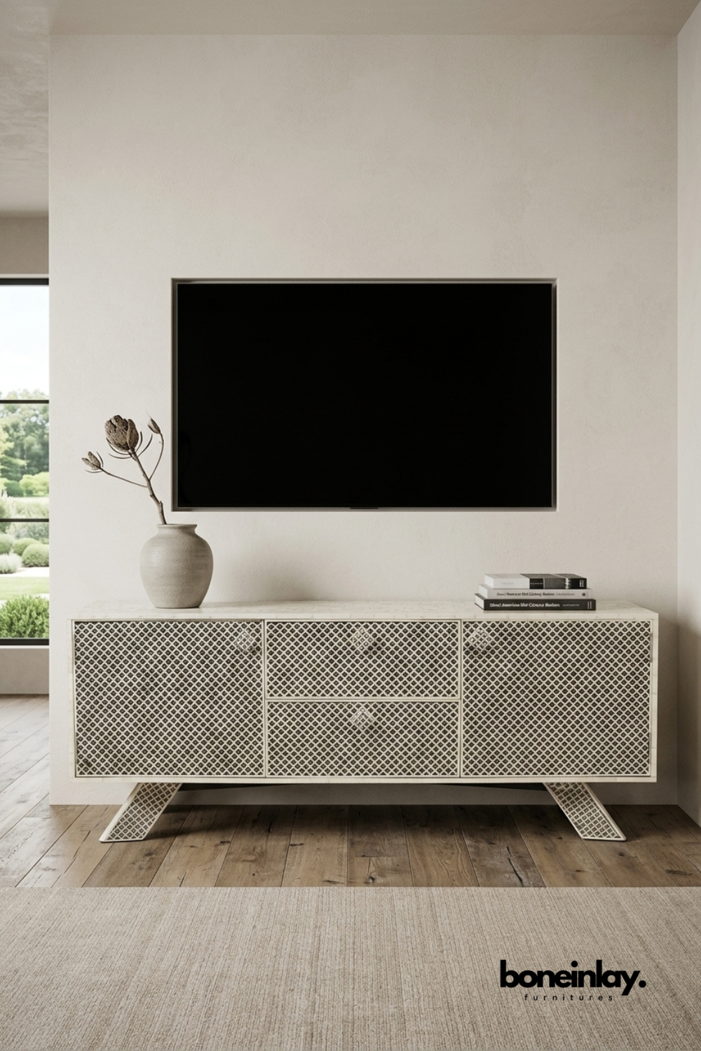 Ivory bone inlay TV console featuring an intricate lattice trellis pattern across doors and drawers. Angled tapered legs with matching inlay detail add a sculptural, modern silhouette. Styled beneath a wall-mounted television with a ceramic vase and stacked books. A refined entertainment unit blending handcrafted texture with contemporary design.