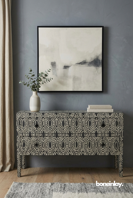 Handmade black and ivory bone inlay floral dresser with two drawers, oval medallion pattern, styled in a modern living room with vase and artwork