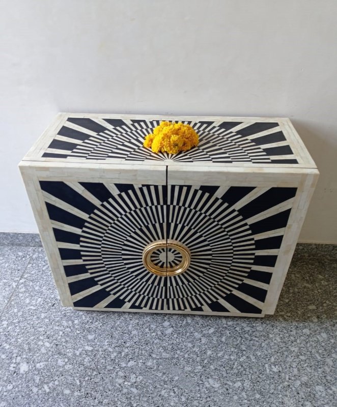 Two-door black and white bone inlay bar cabinet with a bold radial sunburst pattern and oversized circular gold-finished handles.