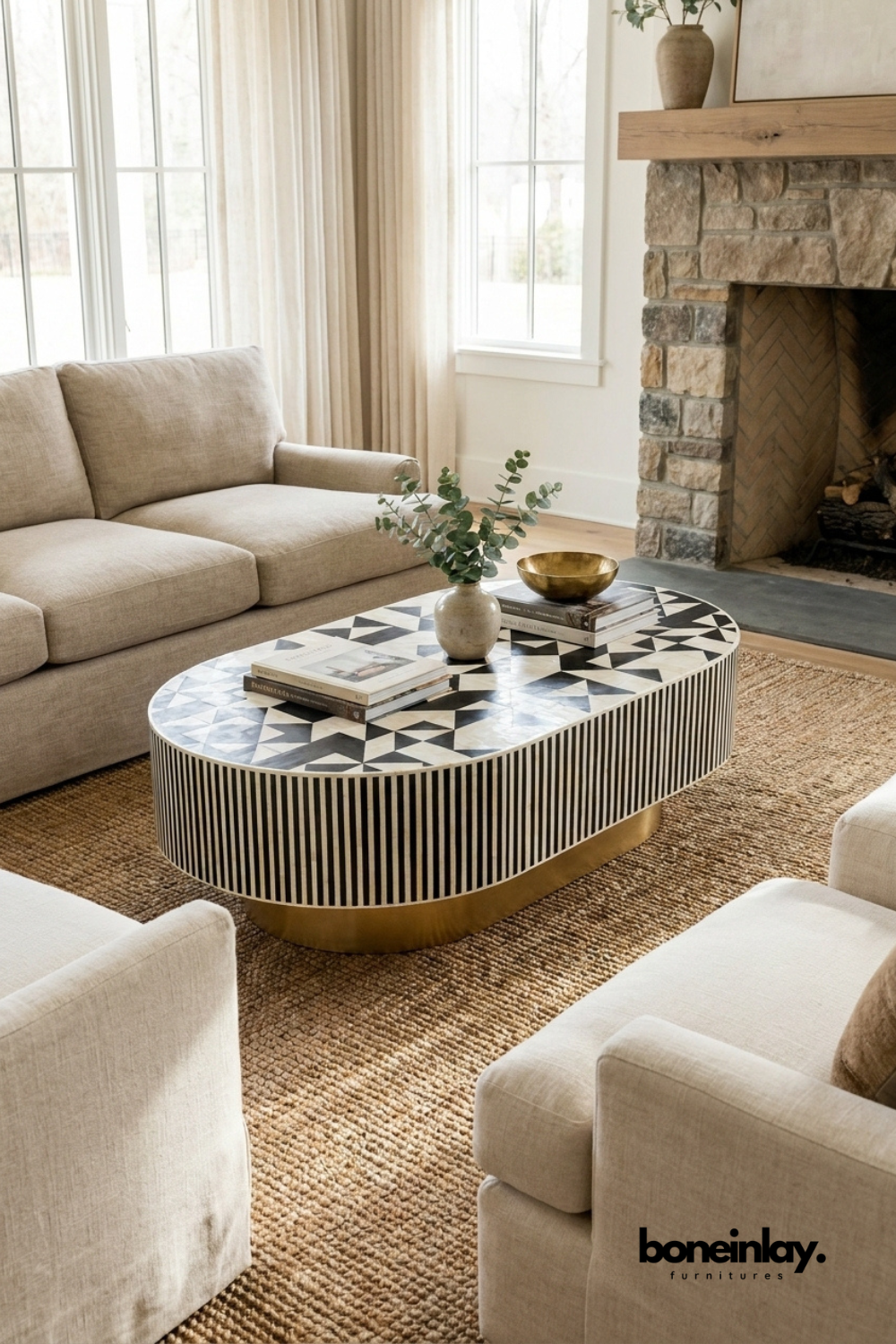 Handmade bone inlay oval black coffee table with brass base styled in a cozy modern living room with fireplace