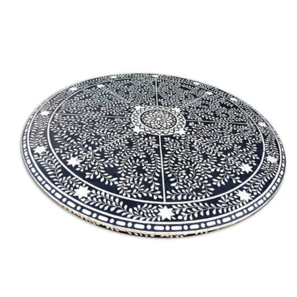 Detailed overhead view of bone inlay round dining table top showing mandala floral vine and star inlay pattern on black background