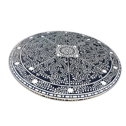 Detailed overhead view of bone inlay round dining table top showing mandala floral vine and star inlay pattern on black background