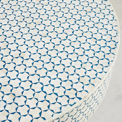 Close-up top view of the blue and white bone inlay coffee table, showing the circular tabletop with its repeating geometric inlay pattern, handcrafted bone surface, and contrasting blue color details clearly across the Moroccan design.