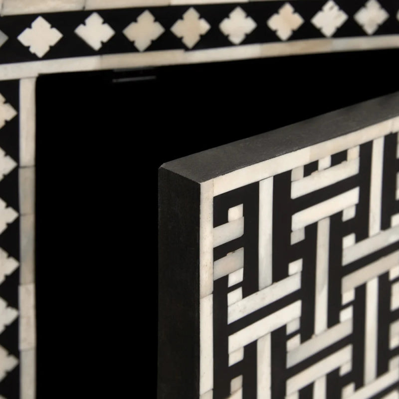 Extreme macro of handmade bone inlay sideboard showing white quatrefoil top border row, hand-laid basket weave mosaic door panel, and solid black mango wood frame thickness.