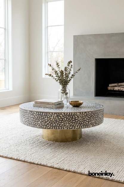 Round grey bone inlay coffee table with scrolling vine pattern and brushed brass pedestal base