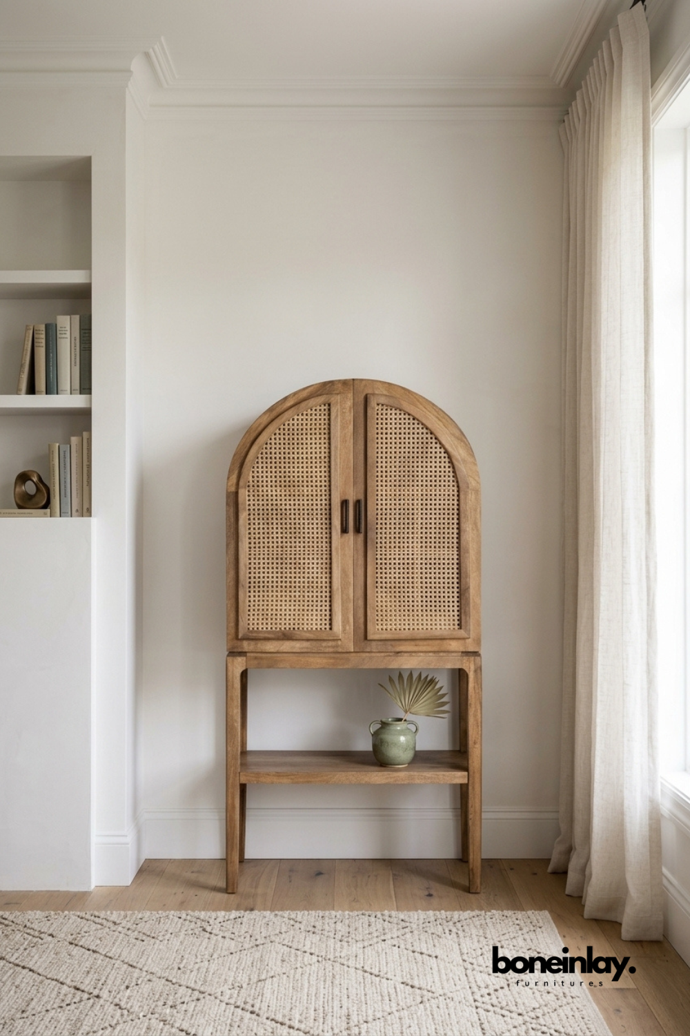 Arched natural rattan cane cabinet with a wood frame.
Two cane-front doors sit above an open wood shelf base.
Rounded arch top adds a soft, organic silhouette.
Fits neatly into a nook beside a built-in bookshelf.