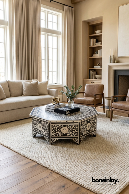Handmade black and white floral bone inlay octagonal coffee table with drawers, styled in a neutral beige living room with sofa and armchair
