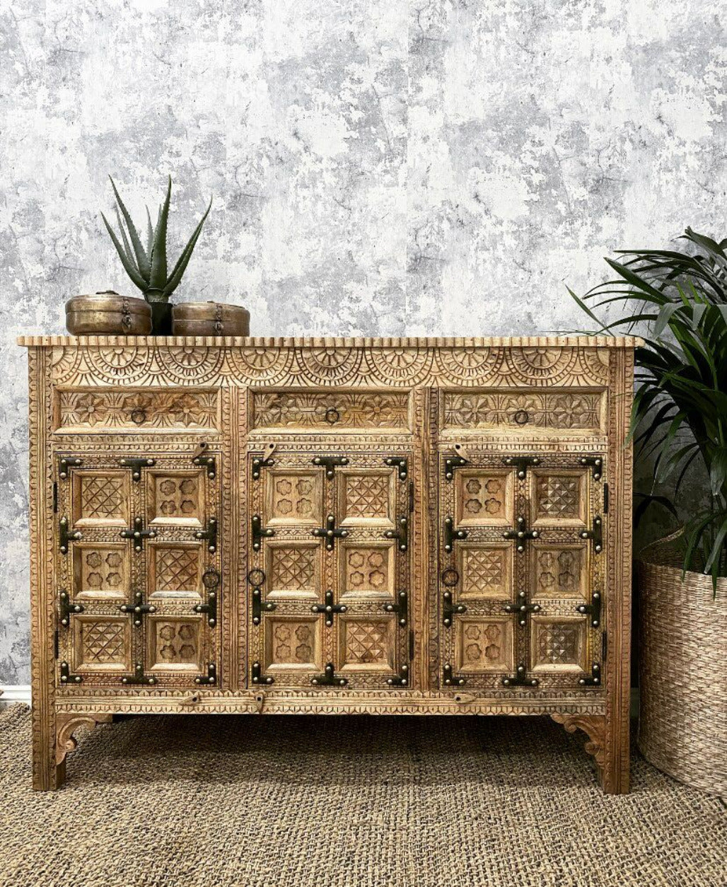 Hand-carved solid wood Indian 3-door sideboard buffet with antique iron straps and sunburst carvings in natural warm wood finish.