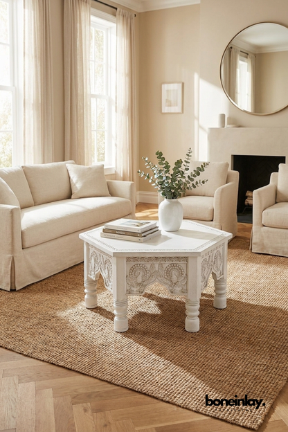 Octagonal white hand-carved wooden coffee table featuring traditional Indian floral patterns and ornate arched legs.
