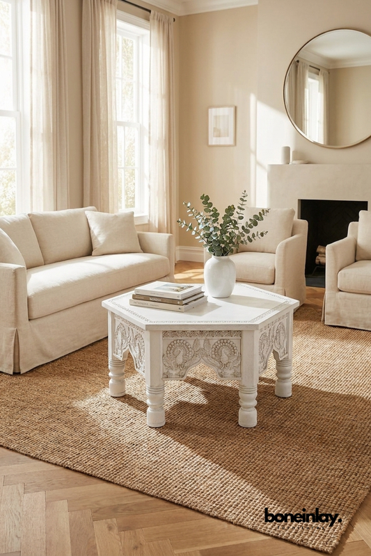 Octagonal white hand-carved wooden coffee table featuring traditional Indian floral patterns and ornate arched legs.