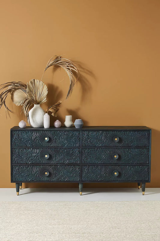 Anthropology black Gulliver chest of drawers in a natural wood finish, with six drawers and carving across the front.