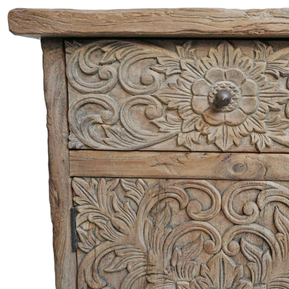 Iron knob bedside cabinet in rustic solid wood, close-up of drawer handle surrounded by carved floral scrolls.