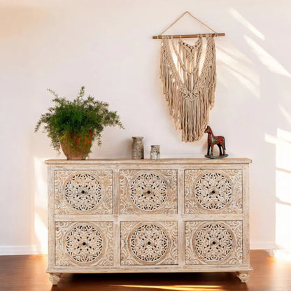 Ivory medallion six-drawer bureau with carved hardware, front view styled with vase and plant.