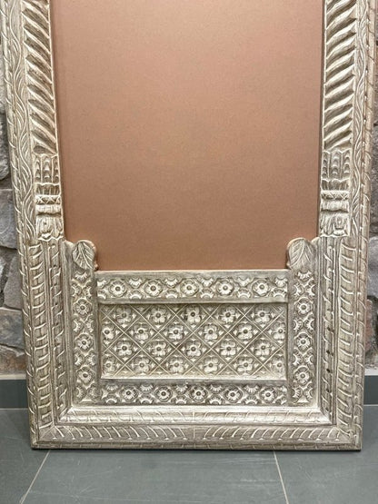 Jharokha arch standing mirror in distressed solid wood, base detail view showing floral lattice and carved trim.