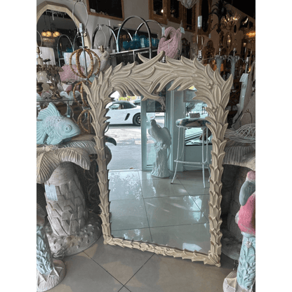 Leaf frame decorative mirror in rustic carved wood, front view with a tiled floor and doorway reflected in the glass.