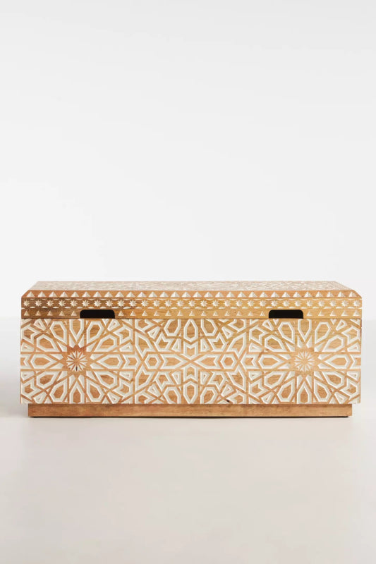Light wood storage toy chest viewed from above, showing its plain closed lid and dark fittings near the edges.