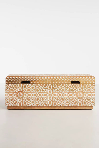 Light wood storage toy chest viewed from above, showing its plain closed lid and dark fittings near the edges.