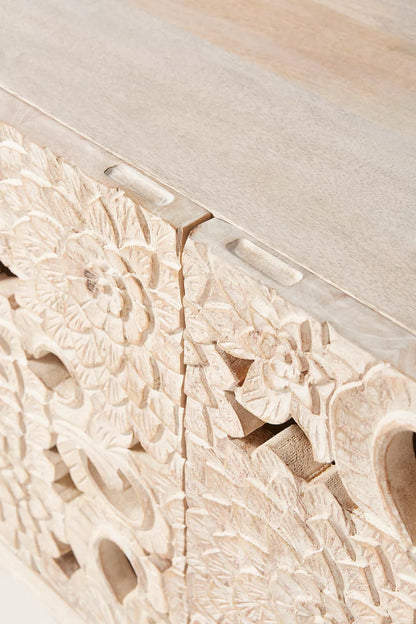 Warmth Lotus Console in wood, shown in a close-up view of the repeated lotus cutouts across its carved cabinet door.