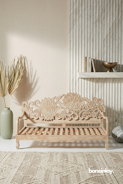 Lotus daybed made of light-toned solid wood featuring an expansive, intricate hand-carved floral backrest in a neutral, sunlit living space.
