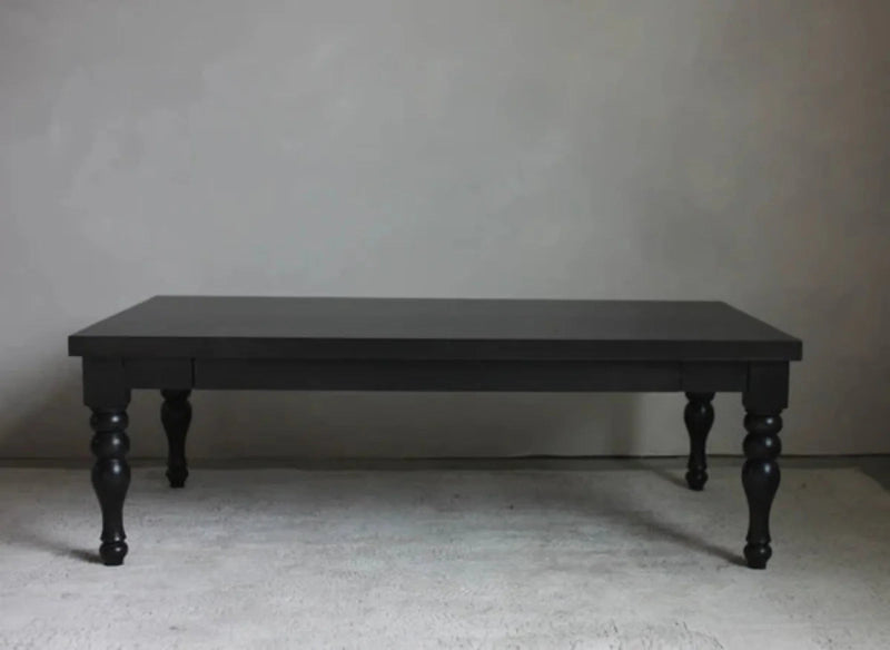 A luxury hand-carved solid wood coffee table in a matte black finish with intricate spindle-turned baluster legs against a neutral background.