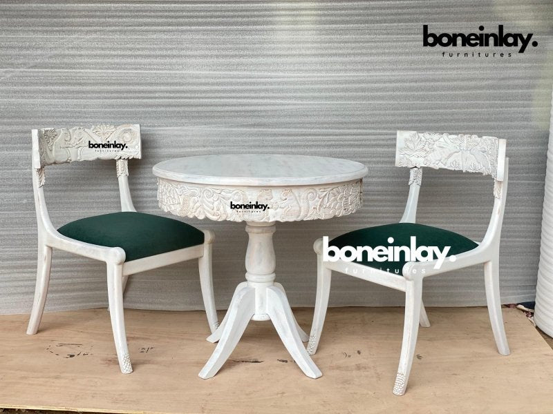 Menagerie round dining suite in carved solid wood, front view with two green seats, animal backrests and curved table feet.