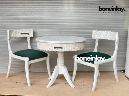 Menagerie round dining suite in carved solid wood, front view with two green seats, animal backrests and curved table feet.