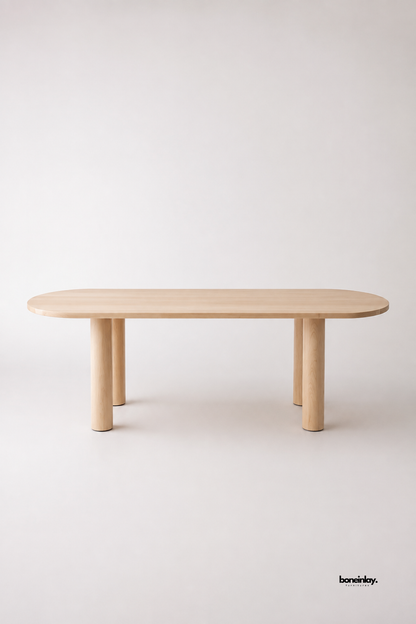 Artisan-crafted light natural oak oval dining table showcasing chunky round post legs and clean pill-shaped contours against a soft white background. This versatile wooden conference and dining table offers timeless minimalist aesthetics and sturdy craftsmanship for modern dining spaces.