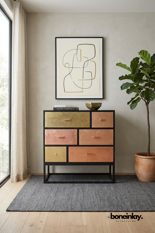 Black metal-framed dresser featuring six mixed-tone leather drawer fronts in blush, terracotta, and olive hues. Brass and wood pulls add warm contrast against the graphic color-block layout. Styled with a brass bowl and design book beneath abstract line art beside a fiddle leaf fig. A playful statement dresser for modern eclectic bedrooms and living spaces.