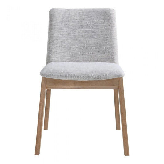 Front view of a modern minimalist dining chair with light wood legs and grey fabric upholstery against a white background.