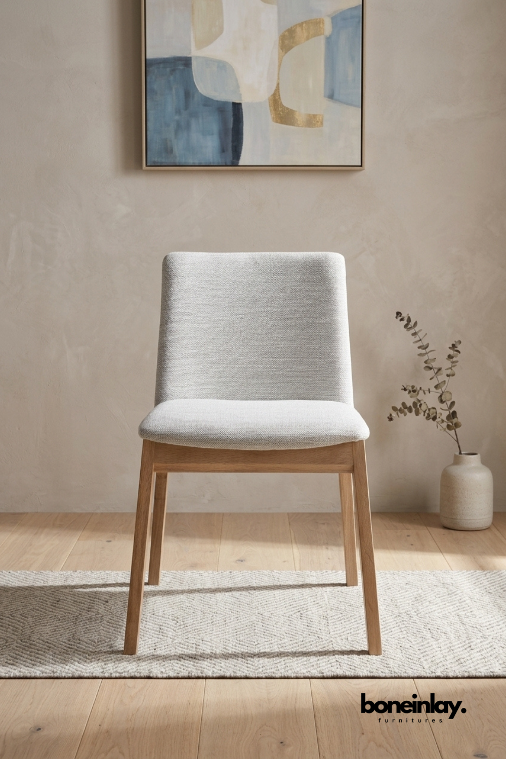 Modern upholstered dining chair with light grey fabric seat and solid oak wood frame for dining room, kitchen, or contemporary interiors.