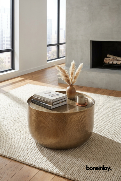 Round hammered metal coffee table with warm bronze finish and tray style top in a contemporary living room