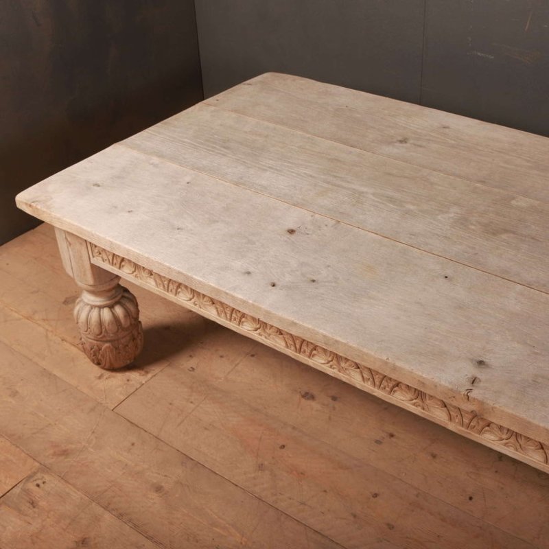 Natural wood accent table with a broad rectangular surface and thick edge, seen from above at an angle on a wood floor.