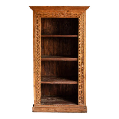 Natural wood bookshelf, front view showing its tall open frame, four shelves and carved border against a white wall.