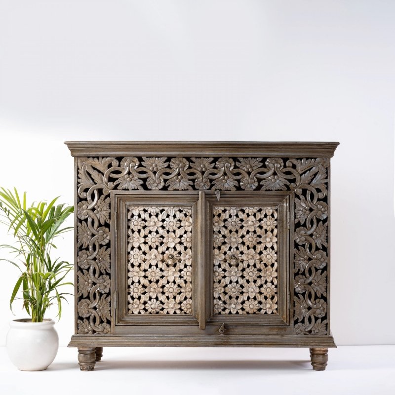 Natural wood floral buffet, front view showing two pierced flower doors, carved vine surrounds and short turned feet.
