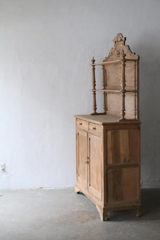 Natural wood kitchen hutch with open upper shelves and a deep lower cabinet, side view against a light wall.