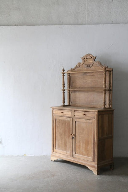 Natural wood Welsh dresser with a carved crown above open shelves and a two-door base, shown from the front
